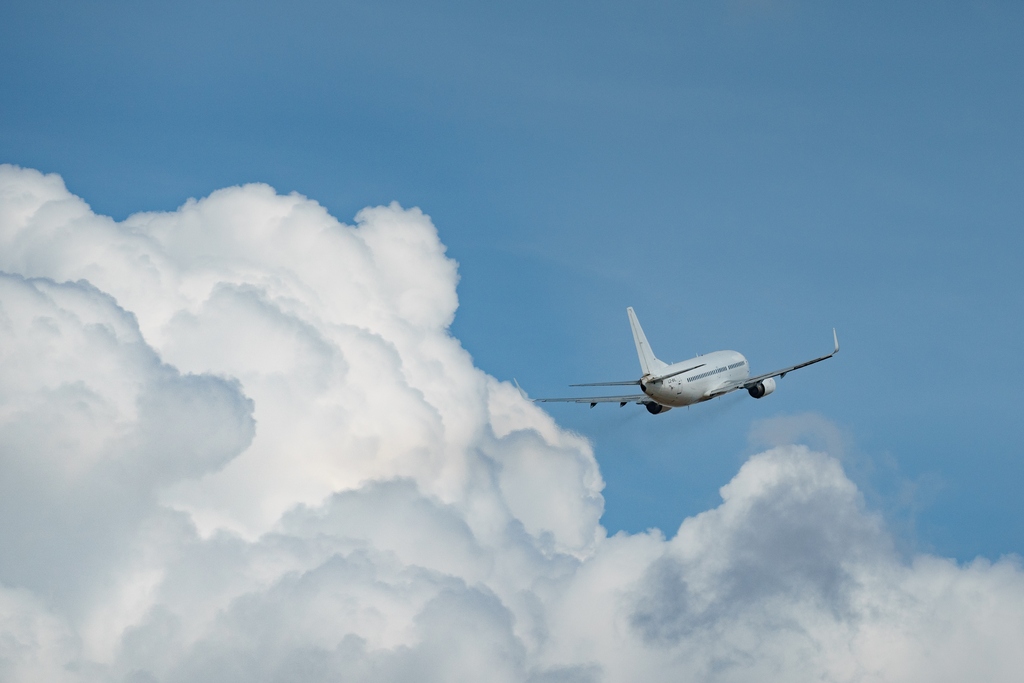 Flugzeug am Himmel, viele Wolken